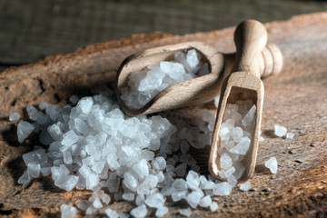 Cyprus sea salt flakes over bark on wooden background