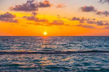 Beautiful sunset with sky over calm sea  in tropical Maldives island