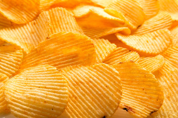 background corrugated delicious golden chips with texture close-up macro and sunlight