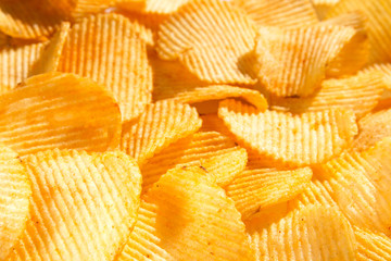 background corrugated delicious golden chips with texture close-up macro and sunlight