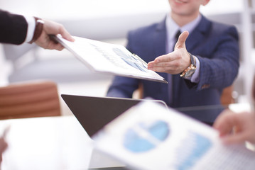 Discussing the scheme. Side view of business people, pointing handles on the chart together, sitting at the table