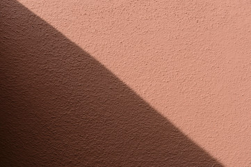 Fototapeta premium shadow and sunlight on a red wall background, diagonally splited