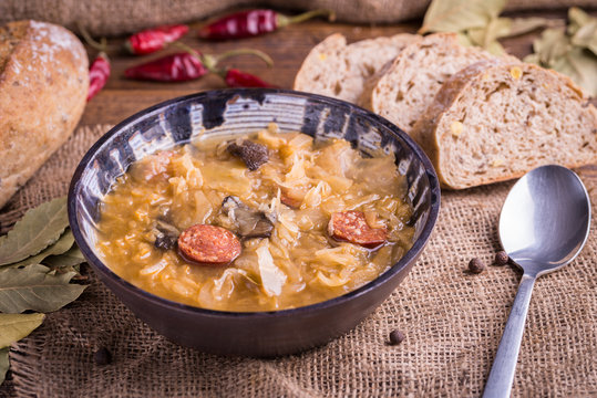 Christmas cabbage soup kapustnica with mushrooms, bread and spoon on natural background.