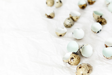 Fototapeta na wymiar Egg husks and quail eggs on crumpled paper on white background.
