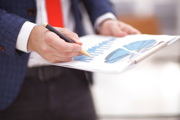 Discussing the scheme. Side view of business people, pointing handles on the chart together, sitting at the table