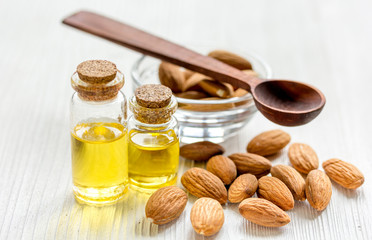 cosmetic and therapeutic almond oil on light wooden background