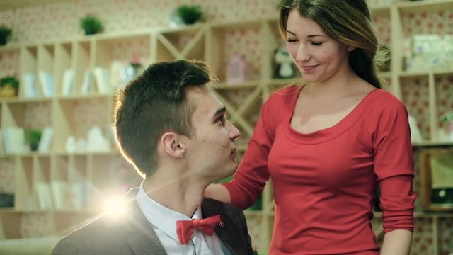 Couple sitting on the sofa in arms and caressing each other. Slow motion happy