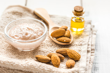 natural scrub with almond oil and towel on light table background