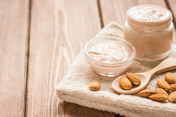 Obraz na płótnie Canvas body scrub with almonds for body care on wooden table background