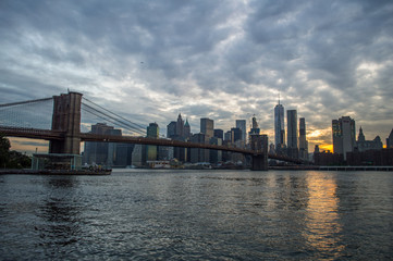 Fototapeta na wymiar Manhattan Downtown Financial District Skyline and Brooklyn Bridge as Seen from Mainstreet Park in Brooklyn at Sunset, USA