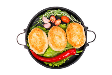 Fried cutlets with vegetables, herbs and spices in a frying pan