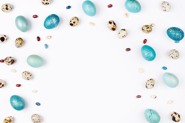 background with quail and blue Easter eggs,  and candies. Flat lay, top view. Easter concept.