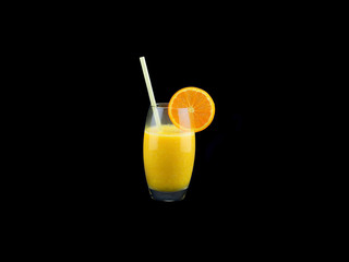 A glass with fresh orange juice isolated on black background