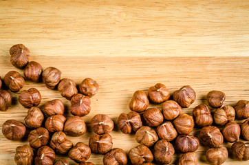 toasted hazelnuts without shells, on wood, background