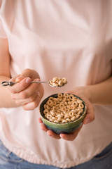 Closeup of woman's hands holding bowl with organic whole wheat cereal. Healthy Breakfast or snack. Healthy food and eating.