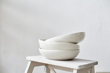 Samples handmade ceramic white plates on wooden table, working process in studio - obrazy, fototapety, plakaty