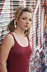 Fototapeta na wymiar Cautious Teen Girl in Alley with Graffiti