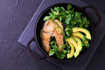 Grilled sheatfish fish steak with avocado, arugula and salad