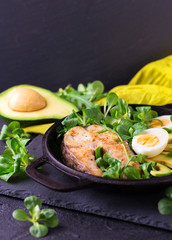 Grilled sheatfish fish steak with avocado, arugula and salad