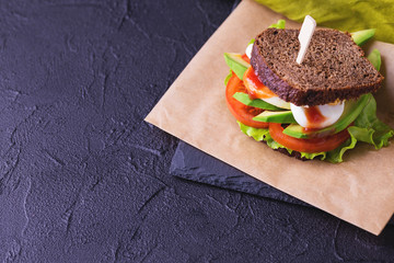 Sandwich with tomatoes, lettuce, avocado, boiled egg and sauce