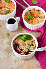 Crumble with berries, oatmeal and nuts on a concrete background