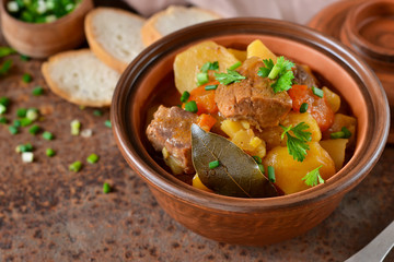 Stew with vegetables and potatoes on an old grunge background