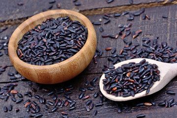 Black rice in a wooden spoon and bowl