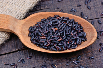 Black rice in a spoon on table