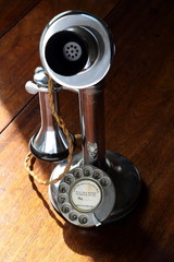 Retro chrome candlestick telephone on wooden desk 
