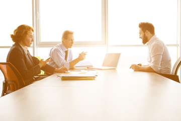 Toned of job interviewer giving his CV to be admitted to huge company, firm, enterprise. Handsome man communicating with employees in board room in office.