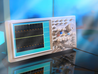 Modern electronic oscilloscope on abstract background