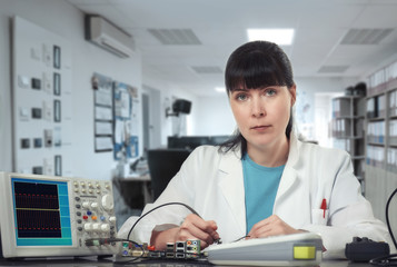 Fototapeta na wymiar Young female tech or engineer repairs electronic equipment