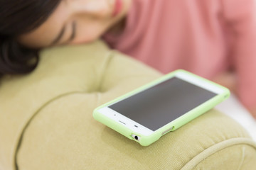 眠る女性とスマホ