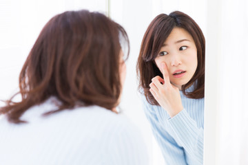 鏡を見る女性　スキンケア