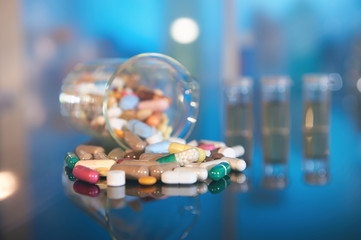 Assorted pills or capsules with medications on dark abstract background