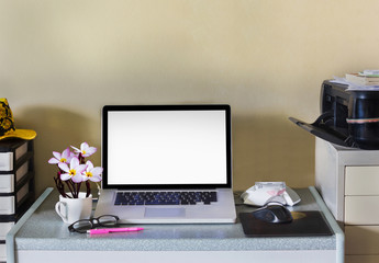 Blank screen laptop or empty space on screen of notebook on working table and flower in cup