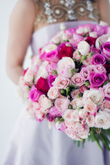 Woman in a white dress holding a flower bouquet.