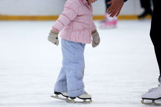 the girl helps the child to skate.