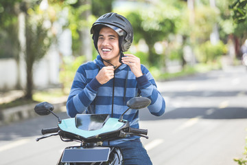 man fastening his motorbike helmet