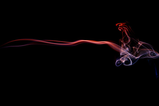 Abstract art. Color red blue smoke from the aromatic sticks on a black background. Background for Halloween. Texture fog. Design element. The concept of aromatherapy.