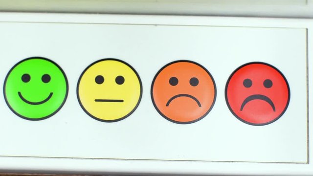 4 in 1. The finger presses on emoticons with different emotions. A person chooses his mood. A man switches from sadness to happiness. A group of buttons with an image of smiles 4k.