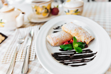 Pancakes with chocolate, fresh strawberry and mint