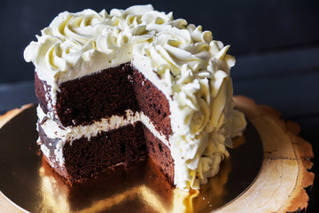 Beautiful biscuit cake in white cream and piece is cut off