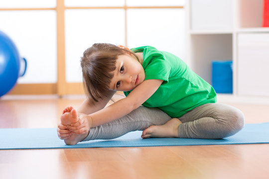 cute little girl stretching in gym