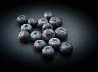 Natural looking blueberries on dark background. Top view. Selective focus in the middle.