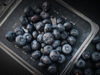 Natural looking blueberries on dark background. Top view. Selective focus in the middle.