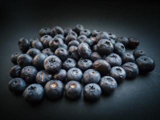 Natural looking blueberries on dark background. Top view. Selective focus in the middle.
