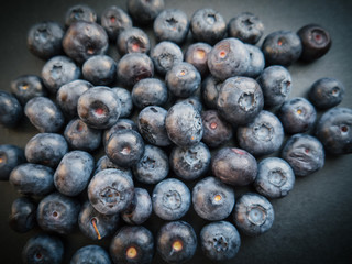 Natural looking blueberries on dark background. Top view. Selective focus in the middle.