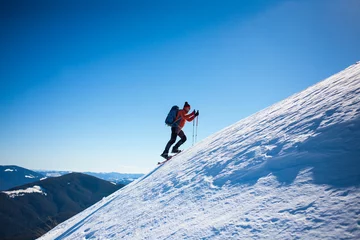 Rolgordijnen Climber in the winter mountains. © zhukovvvlad