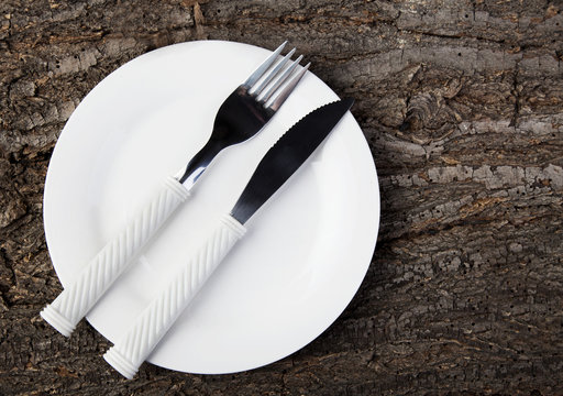 Plate with fork knife empty wooden table
